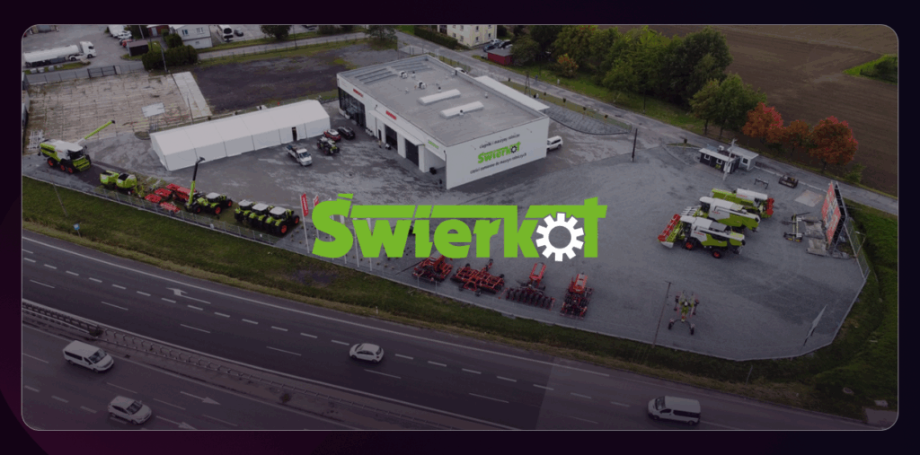 This image shows an aerial view of the Świerkot company facility with agricultural machinery displayed outside. The company logo is prominently featured in the centre of the photo